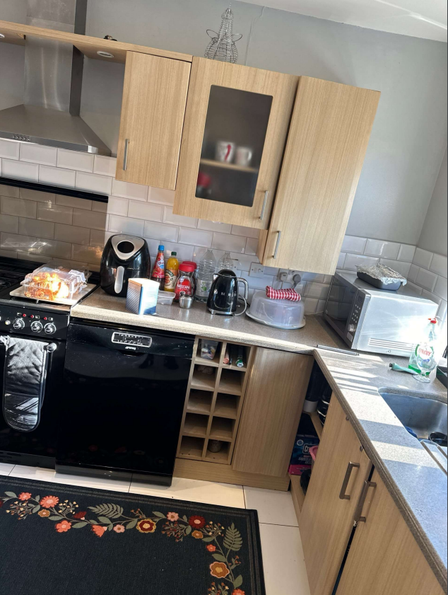Outdated kitchen with light woodgrain cabinets and dark worktops before makeover