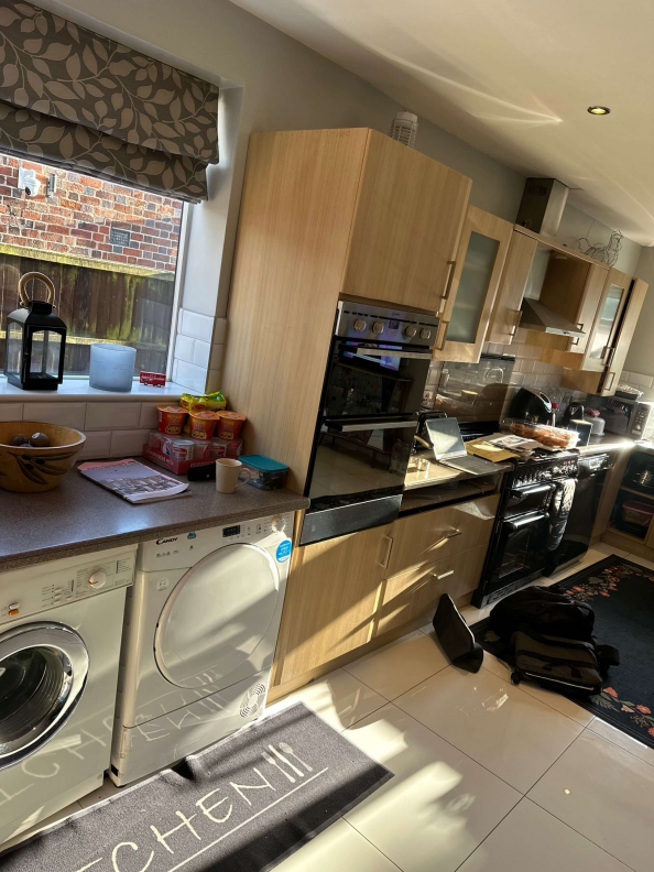 Outdated kitchen with light woodgrain cabinets and dark worktops before makeover