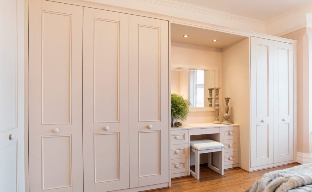 Design visualisation of warm white panelled wardrobe doors with matching handles and dressing table